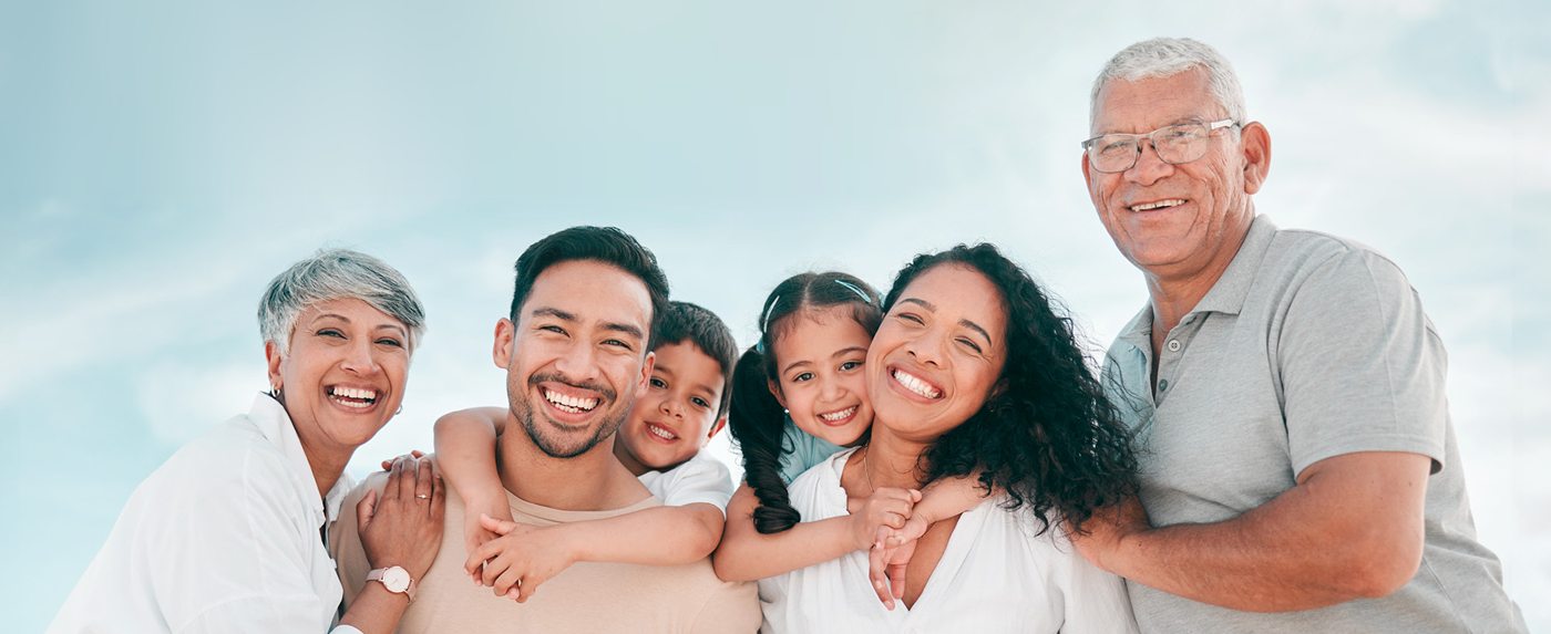 Familia de tres generaciones sonriendo al aire libre